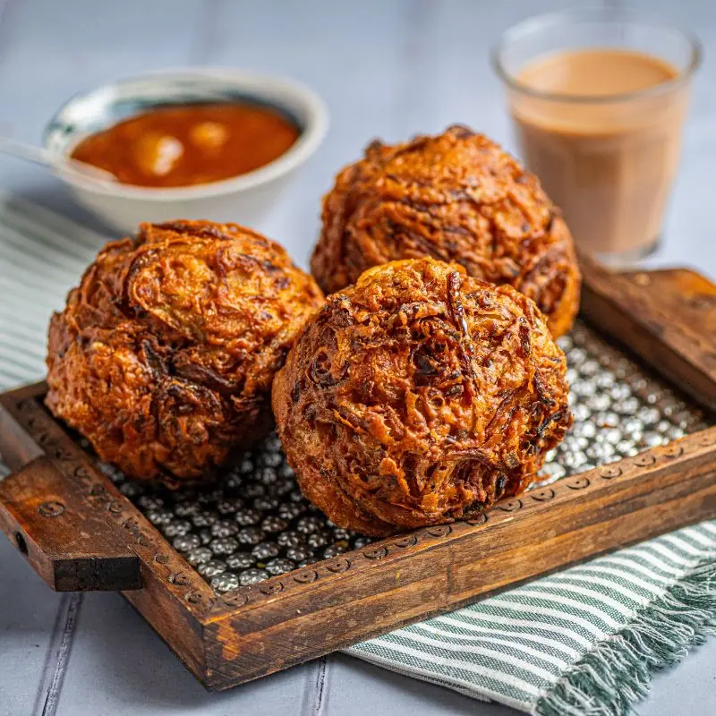 Crispy homemade Onion Bhajis freshly prepared with sliced onion and traditional Indian spices.