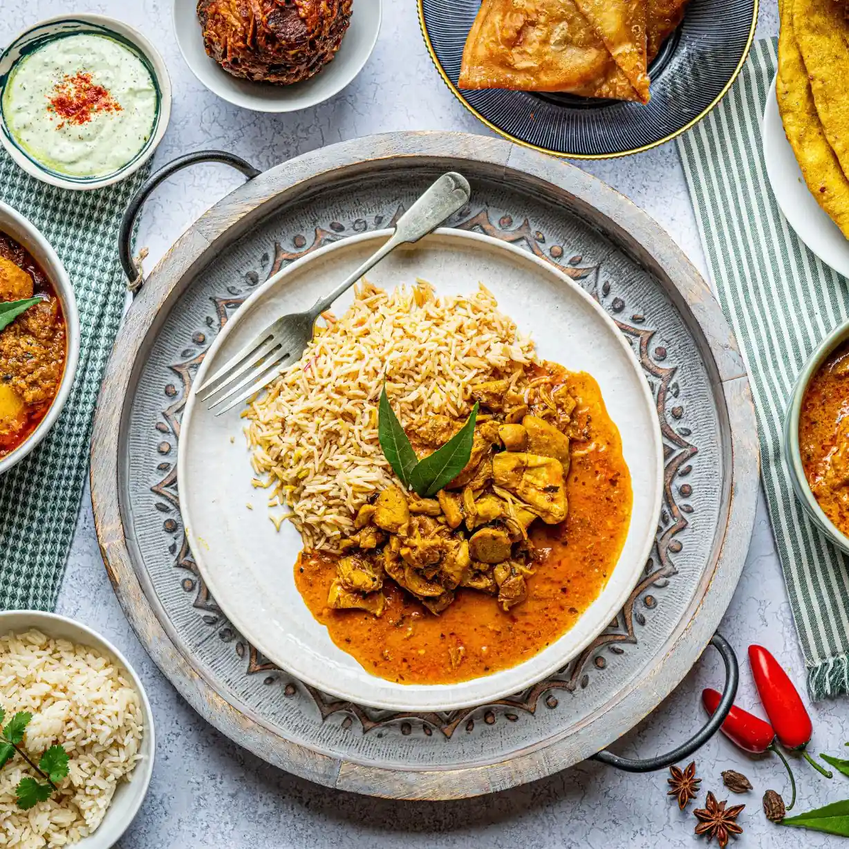Chicken tikka curry served with pilau rice on a tray view full menu page | Alvi's Homemade