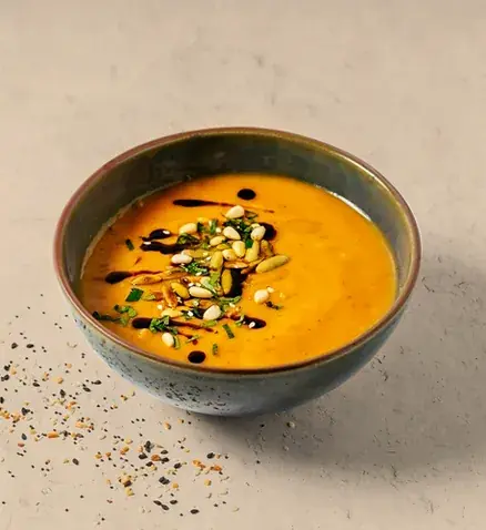Warm bowl pumpkin soup topped with toasted seeds and herbs | Alvi's Homemade
